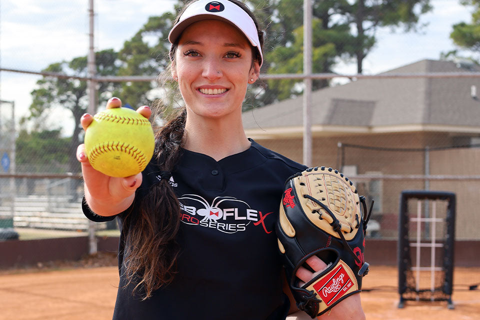 Nicole May holding a ball toward the camera, smiling
